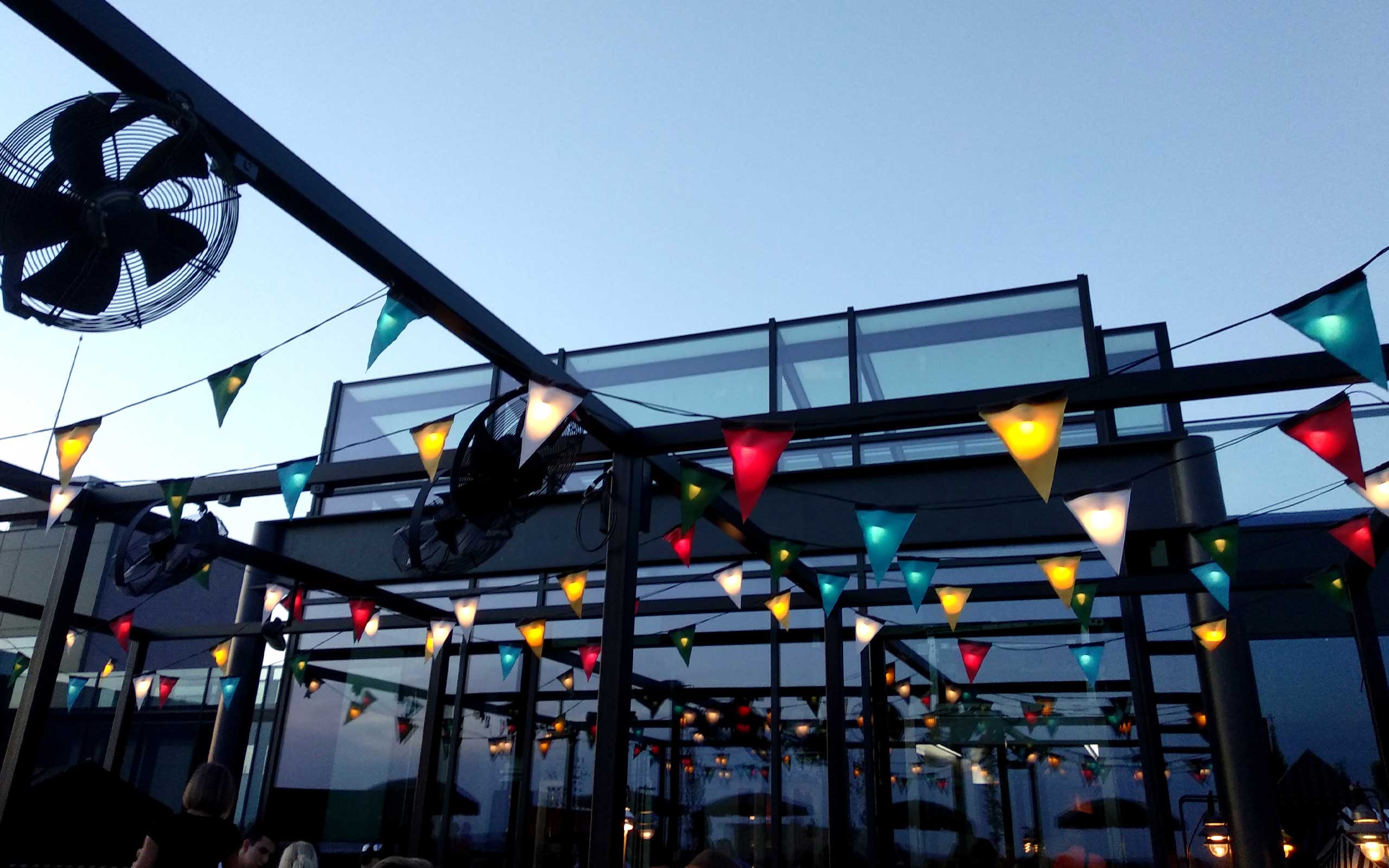 Dachterrasse mit bunten Wimpelketten in der Abenddämmerung